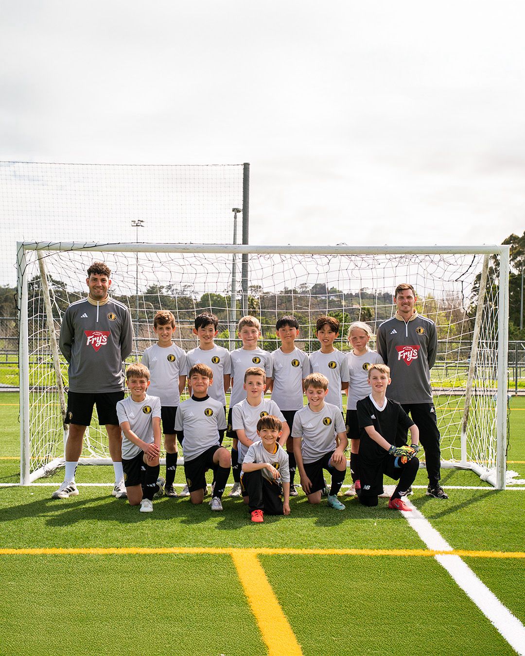 Only Ballers team photo with coaches in front of goal